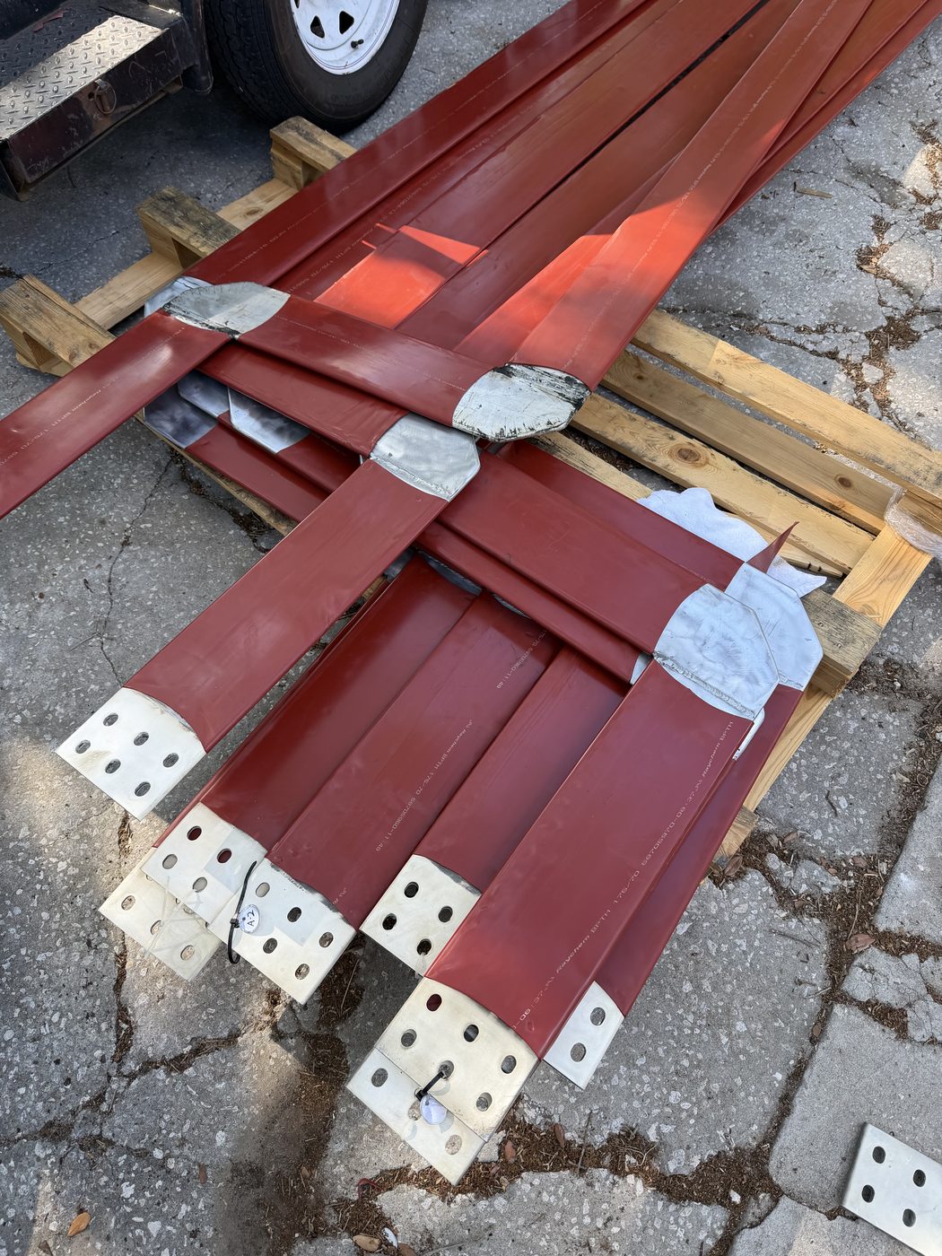 Refurbished 13.8 kV generator bus bar sections on pallet — new Raychem insulation installed and ends silver-plated, ready for transport back to Duke Anclote Power Plant.