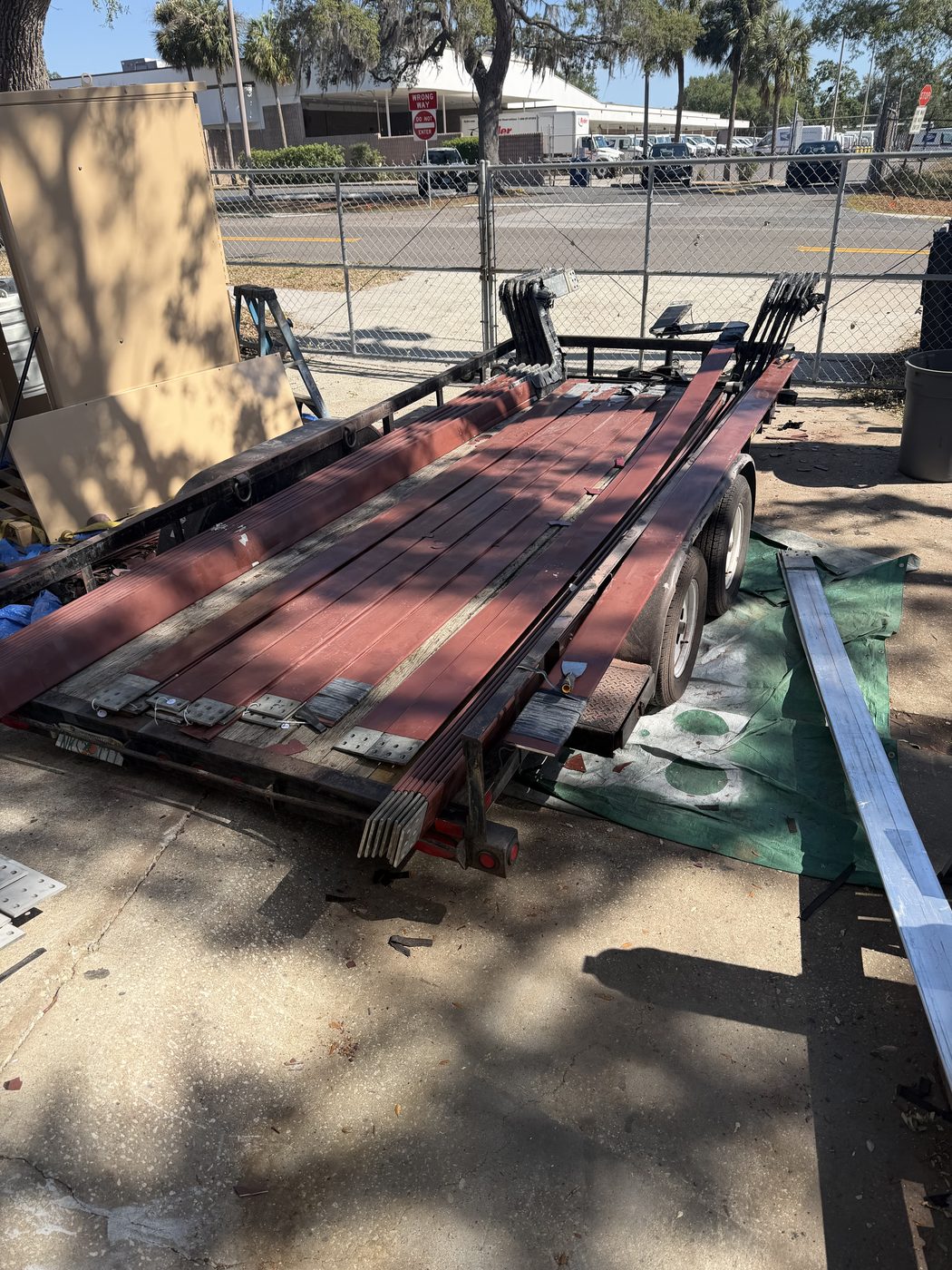 Flatbed trailer loaded with Duke Anclote Power Plant generator bus bar sections arriving at Southern Switch Palm Harbor shop — aged brown Raychem insulation visible, ready for strip and refurbishment.