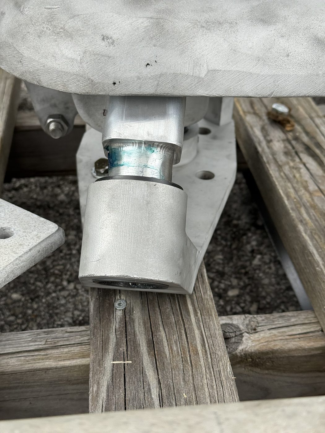 Close-up of the pivot and bushing connection between the new machined arm and the original Southern States EV1 cast housing — fit surfaces visible.