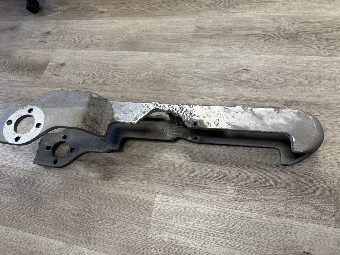 Original 500 kV pantograph switch jaw after lightning strike — aluminum nearly burned through with severe pitting and heat damage across the blade and contact area.