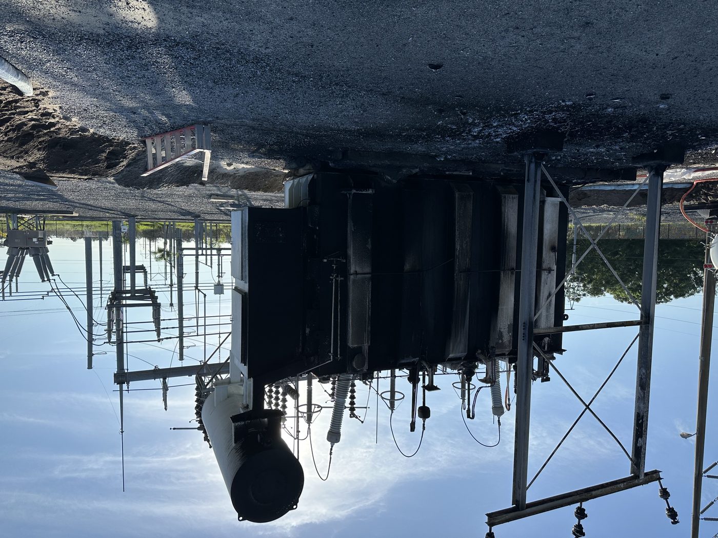 TECO 230 kV autotransformer after catastrophic thermal failure — severe fire damage to the tank and external components. Southern Switch was called in to remove the failed unit and install a replacement.